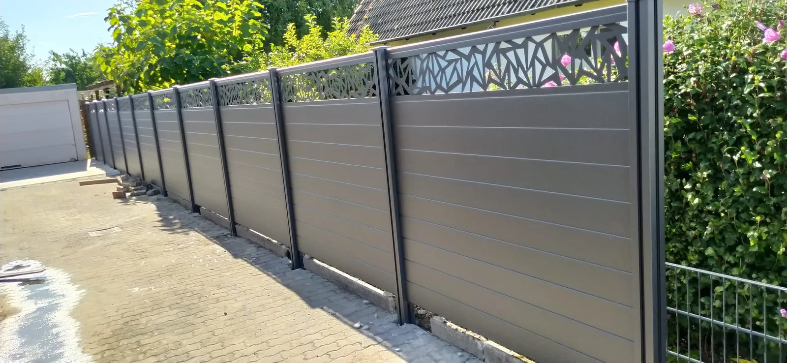 Moderner Sichtschutzzaun in Anthrazit mit Verbundpflaster und sauberer Ausführung in Lübeck
